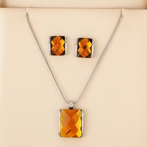 Detail of silver snake chain necklace and earrings with amber rectangular glass stones