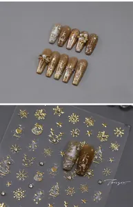 Detailed view of Christmas nail art stickers with gold reindeer and snowflake patterns