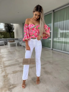 Detail of floral off-shoulder crop top with puff sleeves and white high-waist jeans