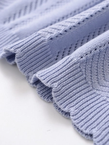 Detail of light blue hollow-out knit texture and ribbed cuff on polo top fabric