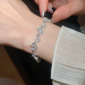 Macro view of butterfly charm bracelet featuring zircon stones and silver-tone finish