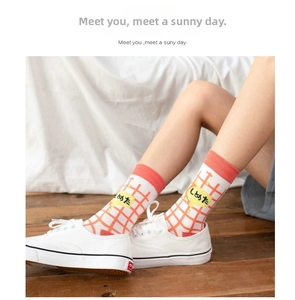 Detail of orange checkered crew socks with Japanese text paired with white sneakers