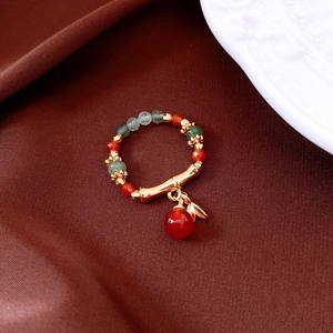 Close-up of vintage tiger eye agate beaded ring with golden leaf and bamboo charms