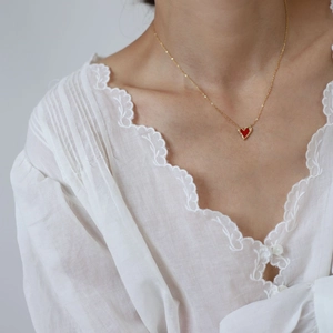 Elegant gold titanium steel heart pendant necklace with red enamel and textured gold edges