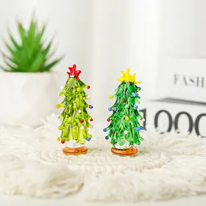Pair of handmade green glass Christmas trees with colorful ornaments on white coasters