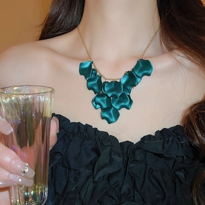 Detailed close-up of a layered petal tassel necklace with emerald green resin petals