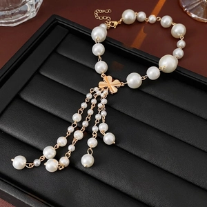 Elegant gold flower tassel necklace with faux pearls and clover pendant on black leather