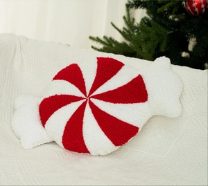 Nahaufnahme des rot-weißen Pfefferminz-Plüschkissens auf einer weichen Strickdecke