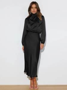 Detail of elegant black satin maxi dress featuring a high turtleneck and draped silk texture