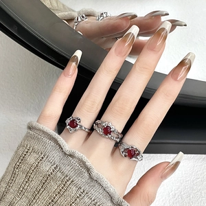 Macro shot of three irregular silver lava rings with ruby gemstones on model's hand