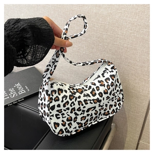Close-up of trendy leopard print shoulder bag with zipper closure and wide strap detail