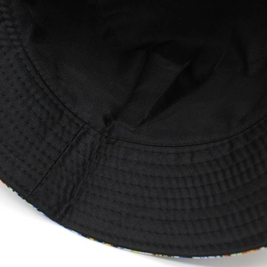 Detailed close-up of stitching on double-sided black bucket hat with cotton twill texture