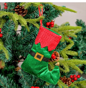 Détail de chaussettes de Noël en velours avec cloches suspendues à un sapin décoré