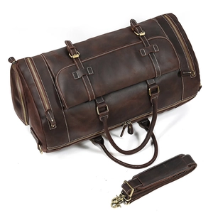 Detail view of deep brown leather travel bag with detachable shoulder strap and hardware