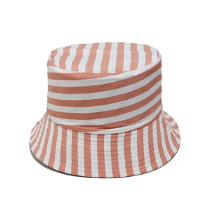 Vue détaillée du tissu en coton à rayures orange et blanches sur un chapeau bob à large bord