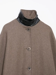 Dettaglio cappotto di lana marrone con colletto in pelle nera a contrasto e bottoni