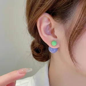 Minimalist double-sided sphere stud earrings in avocado green and lilac purple colors