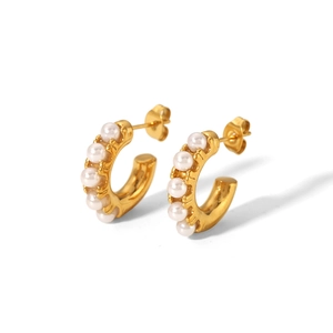 Close-up of golden C-shaped stainless steel earrings with white pearl inlay and butterfly back