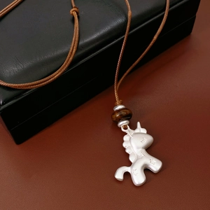 Détail du pendentif licorne en argent S925 avec perle oeil de tigre sur cordon ciré
