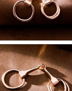 Macro shot of rose gold horsebit silk scarf ring clasp on textured background