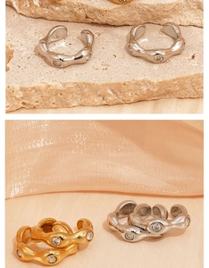 Macro detail of wave-shaped 316L stainless steel ear clips with zircon stones