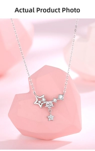 Close-up of 925 sterling silver star fringe necklace with zircon on pink heart prop