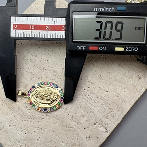 Macro shot showing dimensions of Virgin Mary pendant with colorful zircon using a digital caliper