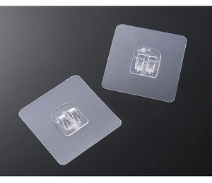 Detail of transparent double-hook adhesive patches with durable U-shaped design for wall mounting