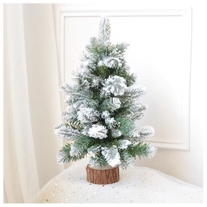 Detailed view of mini flocked Christmas tree with snow effect on a rustic wooden base