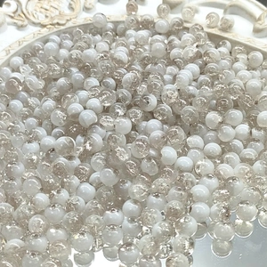 Macro shot of 10mm white and tea-colored ice-crackle glass beads for DIY jewelry making