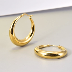 Vista de detalle de aretes de aro de oro de 18K con textura metálica gruesa y pulida