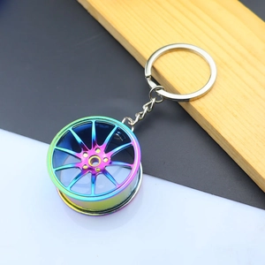 Detail of neo chrome metal car wheel rim keychain with multi-spoke design on wooden block
