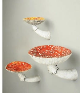 Detailed view of three resin mushroom wall shelves with red caps and white spots