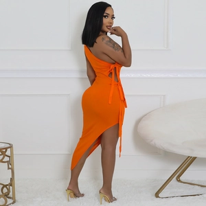 Détail de la robe orange à une épaule avec découpe à la taille et laçage latéral chic