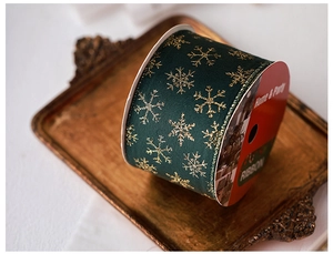 Detail of dark green velvet ribbon with gold glitter snowflakes on a vintage tray