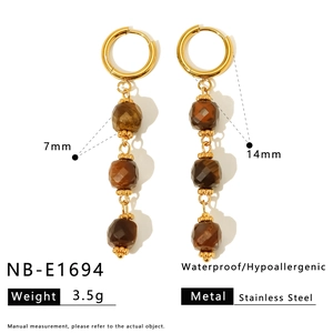 Detail view of 14mm gold stainless steel hoop earrings with 7mm brown stone charms