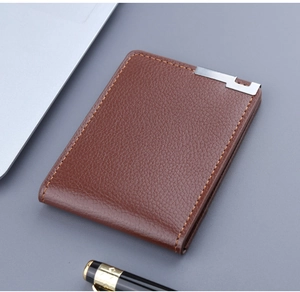 Detailed close-up of brown pebbled leather wallet on desk with business accessories