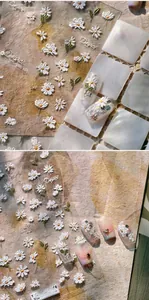 Macro shot of 3D embossed daisy nail stickers with detailed floral embroidery texture