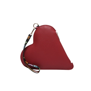 Minimalist red heart-shaped handbag with textured leather and patterned wrist strap