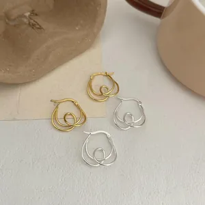 Detailed view of S925 sterling silver knotted hoop earrings in gold and silver finishes