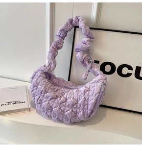Close-up of light purple quilted cloud bag with soft ruched texture and puffed fabric detail