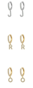 Detail of silver letter J and gold letter R micro-pave charms on huggie hoop earrings