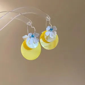 Floral shell earrings with yellow and white circles and blue bead accents for summer