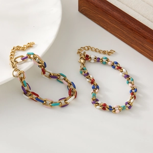 Colorful glazed stainless steel link bracelets set on a ceramic plate with gold finish