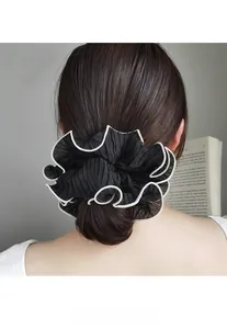 Close-up of a large pleated scrunchie in black and white mesh worn on a ponytail