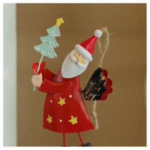 Detail of hand-painted metal Santa ornament with green tree and rustic hanging rope