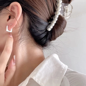 Detail of silver square stud earrings and pearl hair claw clip on model for elegant look