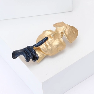 Broche masque en émail artistique avec geste de main sur un support géométrique blanc