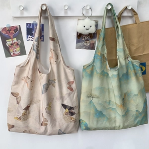 Detail of lightweight canvas tote bags featuring butterfly and mountain landscape prints