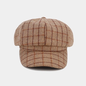 Detailed view of brown plaid texture and stitching on the vintage wool newsboy cap
